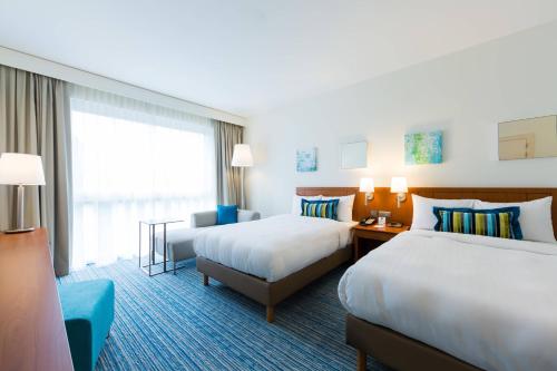 a hotel room with two beds and a window at Courtyard By Marriott Brussels in Brussels