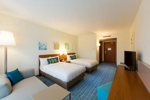 a hotel room with two beds and a tv at Courtyard By Marriott Brussels in Brussels