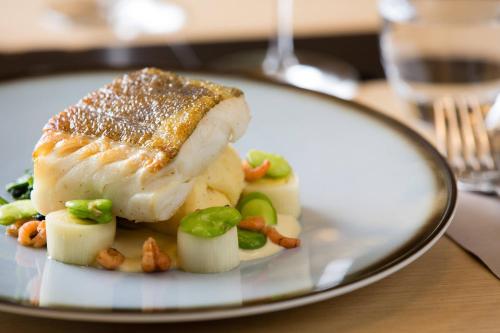 a plate of food with fish and vegetables on a table at Courtyard By Marriott Brussels in Brussels