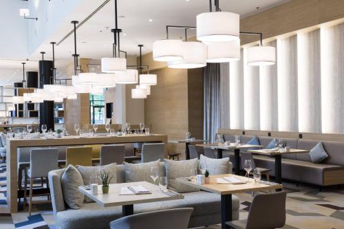 a restaurant with tables and chairs and chandeliers at Courtyard By Marriott Brussels in Brussels