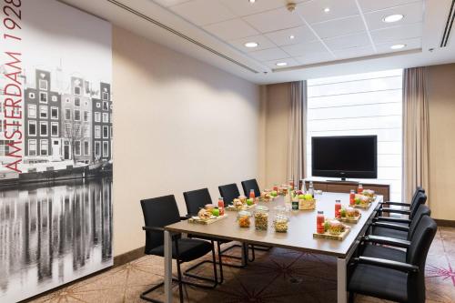 a conference room with a long table and chairs at Courtyard By Marriott Brussels in Brussels