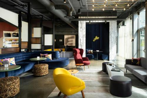 a lobby with couches and chairs and tables at Aloft Waukee in Waukee