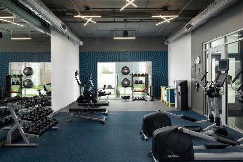 a gym with several treadmills and cardio machines at Aloft Waukee in Waukee