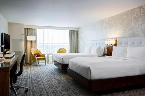 a hotel room with two beds and a television at Renaissance Baton Rouge Hotel in Baton Rouge