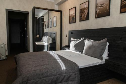 a bedroom with a large bed and a mirror at Meridian in Karagandy