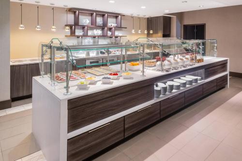 a display case in a restaurant with a lot of food at AC Hotel by Marriott Charlotte City Center in Charlotte