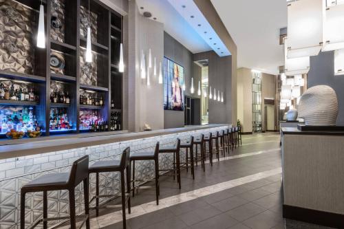 a bar with a row of bar stools at AC Hotel by Marriott Charlotte City Center in Charlotte