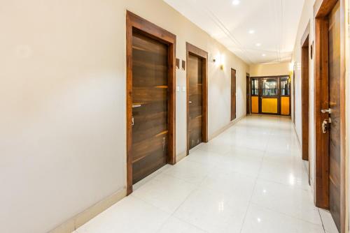 a hallway with wooden doors and a tile floor at Treebo Edge Raipur Railway Station in Raipur