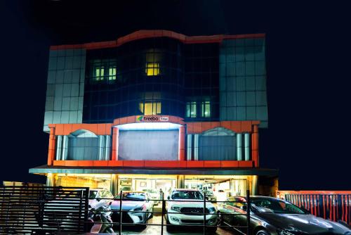 a building with cars parked in a parking lot at Treebo Edge Raipur Railway Station in Raipur