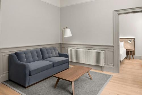 a living room with a blue couch and a table at AC Hotel by Marriott Glasgow in Glasgow