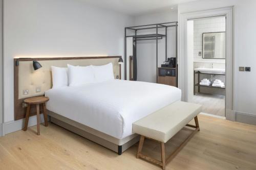 a bedroom with a large white bed and a sink at AC Hotel by Marriott Glasgow in Glasgow