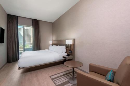 a hotel room with a bed and a couch at AC Hotel by Marriott Charlotte City Center in Charlotte