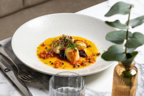 a white plate of food on a table at AC Hotel by Marriott Glasgow in Glasgow