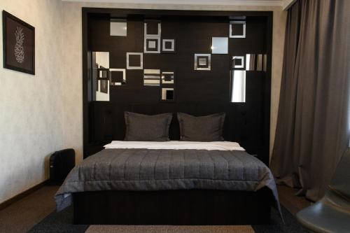 a bedroom with a bed with photographs on the wall at Meridian in Karagandy