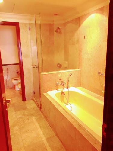 a bathroom with a tub with a shower and a toilet at Fantastic appartment at times square Kuala Lumpur in Kuala Lumpur