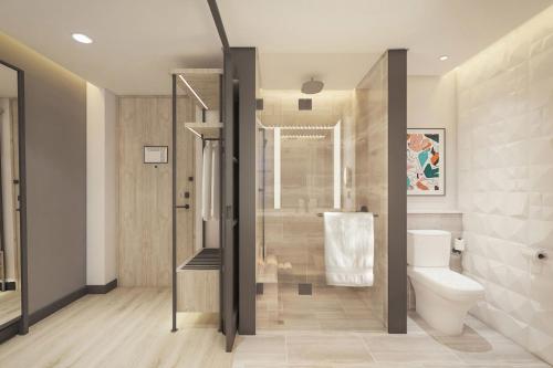 a bathroom with a shower and a toilet in it at Aloft Bali Kuta at Beachwalk in Kuta