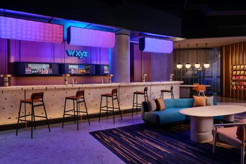 a bar with chairs and a blue couch in a room at Aloft Bali Kuta at Beachwalk in Kuta