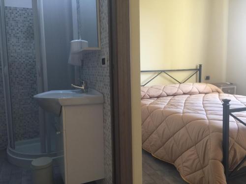 a bedroom with a bed and a sink and a mirror at Mama Lina in Patti