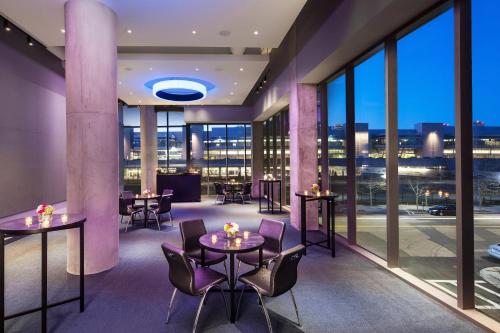 a restaurant with tables and chairs and large windows at Aloft Boston Seaport District in Boston