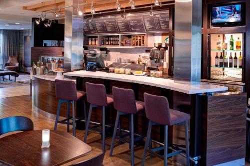 a bar in a restaurant with purple stools at Courtyard Des Moines West/Clive in Clive