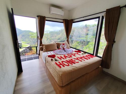 a bedroom with a bed with a view of a mountain at Villane Tumpeng Menoreh in Giripurno