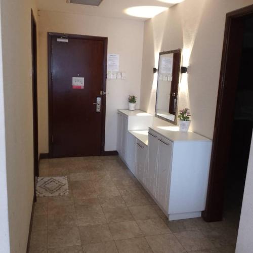 a bathroom with two sinks and a mirror and a door at Fantastic appartment at times square Kuala Lumpur in Kuala Lumpur
