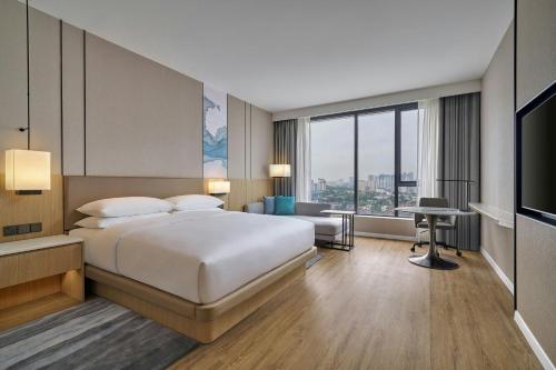 a hotel room with a bed and a television at Courtyard by Marriott Kuala Lumpur South in Kuala Lumpur