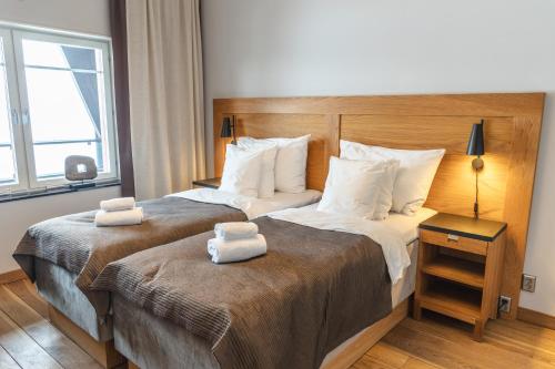 two beds in a hotel room with towels on them at Åre Travel - Tottbacken in Åre