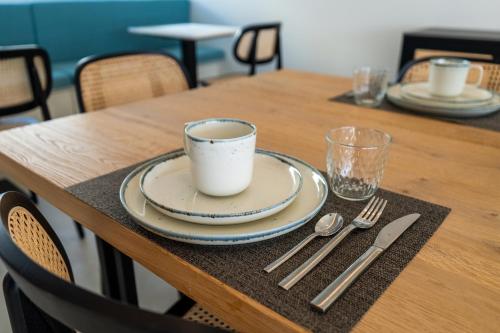 a table with a plate and a cup of coffee on it at Silveira Bay Lounge Retreat in Angra do Heroísmo
