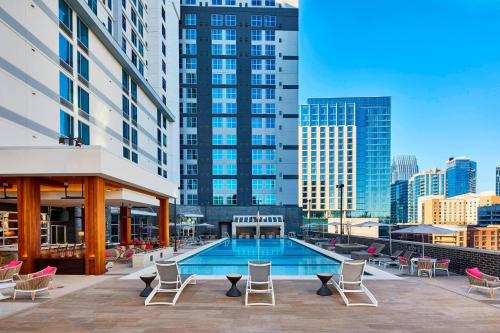 a swimming pool with chairs and a building at Residence Inn by Marriott Nashville Downtown/Convention Center in Nashville