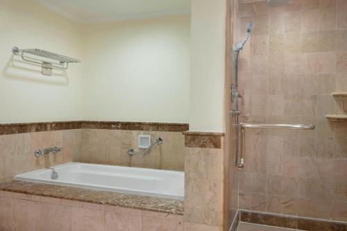 a bath tub in a bathroom with a shower at Sheraton Hanoi Hotel in Hanoi