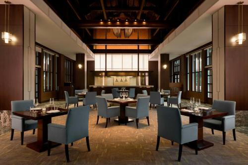 a restaurant with tables and chairs in a room at Sheraton Hanoi Hotel in Hanoi