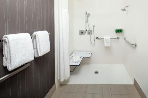 a bathroom with a tub and a sink and towels at Courtyard by Marriott Dayton North in Dayton