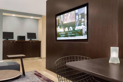 a waiting room with a tv on a wall at Courtyard by Marriott Dayton North in Dayton