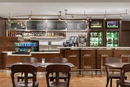 a restaurant with tables and chairs and a bar at Courtyard by Marriott Dayton North in Dayton