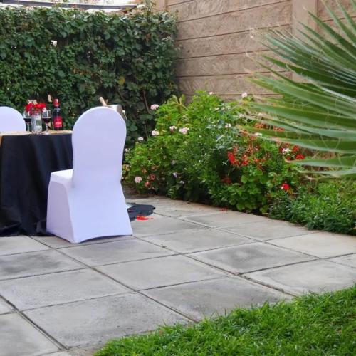a white chair sitting at a table in a garden at Sanel Hotel in Naivasha