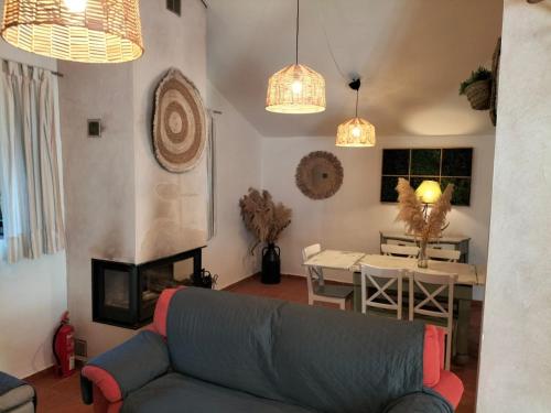 a living room with a couch and a fireplace at Cortijo Rural El Contador, con chimenea in Constantina