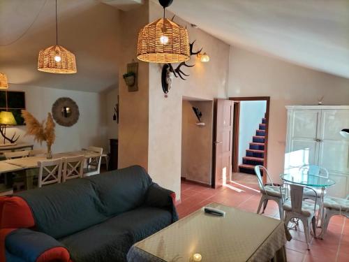 a living room with a couch and a table at Cortijo Rural El Contador, con chimenea in Constantina