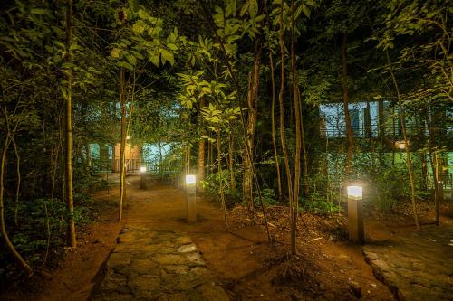 a path in a forest with lights in the middle at Hotel Herb Garden in Udawalawe