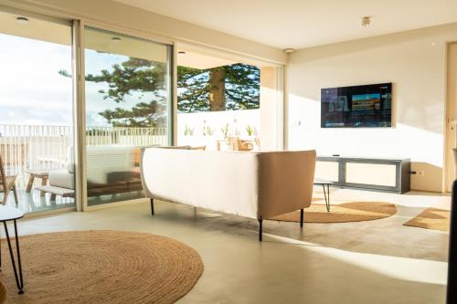 a living room with a white couch and a television at Silveira Bay Lounge Retreat in Angra do Heroísmo