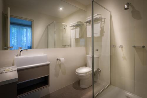 y baño con aseo, lavabo y ducha. en BEST WESTERN PLUS Travel Inn, en Melbourne