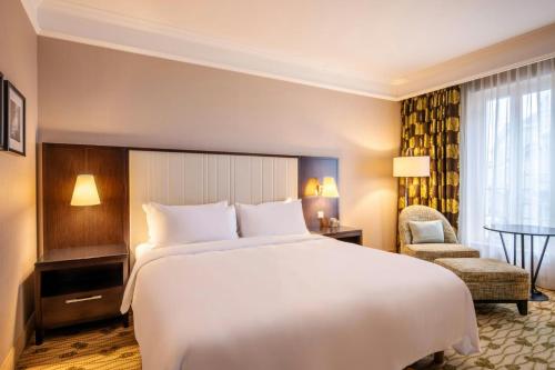 a hotel room with a large bed and a chair at Renaissance Brussels Hotel in Brussels