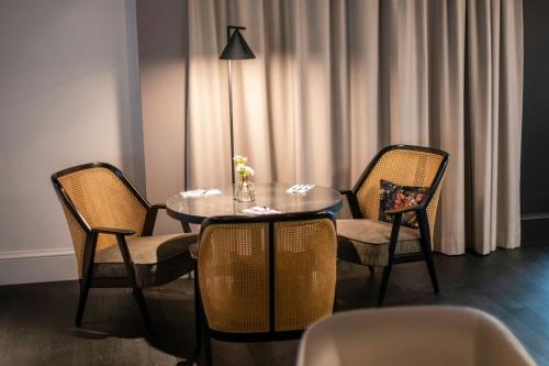 a dining room with a table and two chairs at Renaissance Brussels Hotel in Brussels