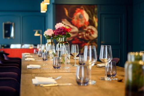 a long table with wine glasses and flowers on it at Renaissance Brussels Hotel in Brussels
