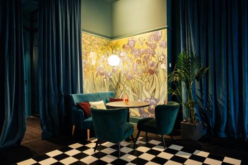 a room with a table and chairs and a painting at Renaissance Brussels Hotel in Brussels