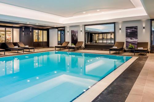 a swimming pool with blue water in a building at Renaissance Brussels Hotel in Brussels