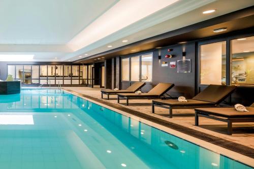 a swimming pool with chaise lounges in a hotel at Renaissance Brussels Hotel in Brussels