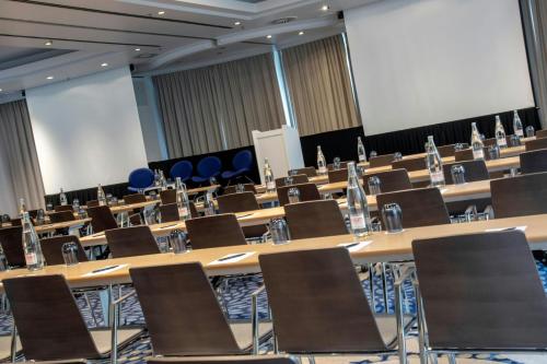 a large room with rows of tables and chairs at Renaissance Brussels Hotel in Brussels