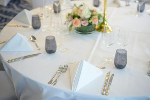 a white table with silverware and flowers on it at Renaissance Brussels Hotel in Brussels