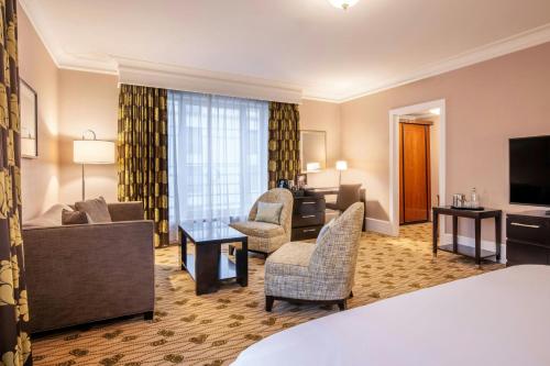 a hotel room with a living and dining room at Renaissance Brussels Hotel in Brussels